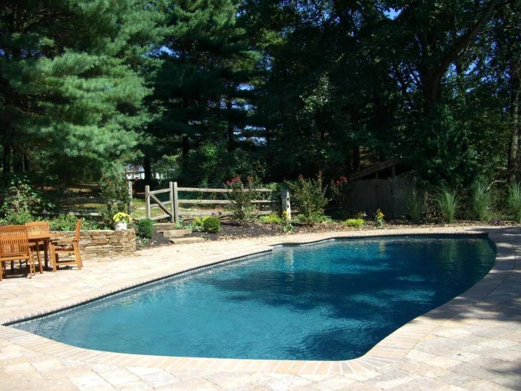 The same pool seen from across the yard, reading as deep natural blue