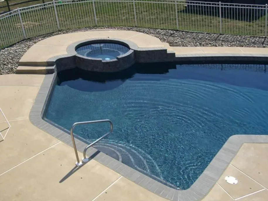After: the pool with gray tile and coping, a rebuilt spa wall and a dark plaster finish